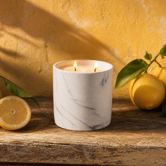 White marble candle refill in cylindrical white marble container with two lit wicks