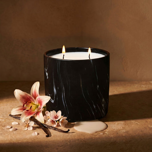 Black marbled jar candle with two flames and white wax, angled view
