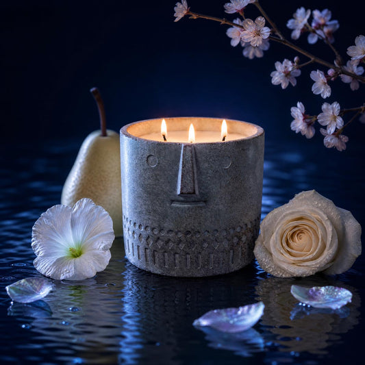 Stone Face candle in blue-gray stone-look jar, three visible flames, face motif front
