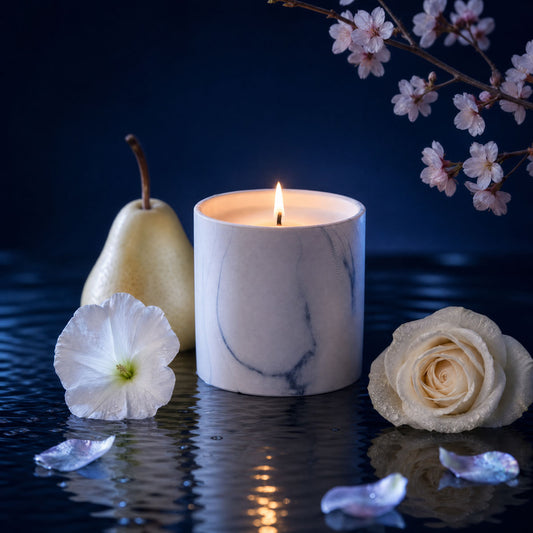 Lit white marble candle with smooth tumbler and subtle gray veining