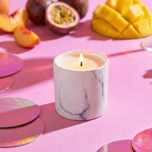 White marble scented candle jar, lit, on tabletop