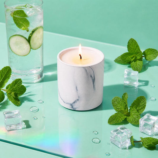 Marble white scented candle in glass jar with gray veining, lit flame