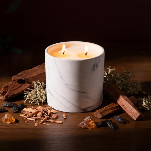 White marble candle refill in white marble jar, two lit wicks on top