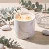 White marble candle refill in round jar with two lit wicks