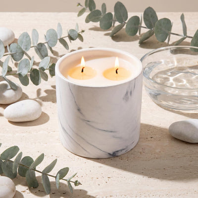 White marble candle refill in round jar with two lit wicks
