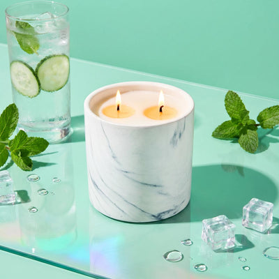 White marble candle refill in white marble jar with two lit wicks