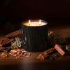 Black marble-pattern candle jar with two lit wicks and visible flame tips