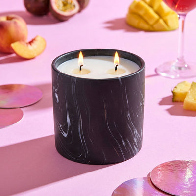 Black marble-pattern candle jar with two lit wicks and white wax