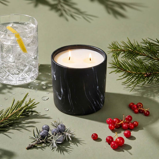 Black marble-pattern candle jar with two lit wicks and white wax surface