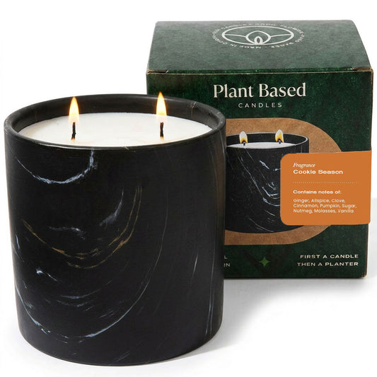 Black Marquina candle in black glass jar with white wax, lit flame