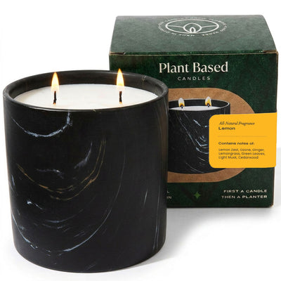 Black Marquina-style 17oz candle jar with lit wicks, plant-based lemon scent.