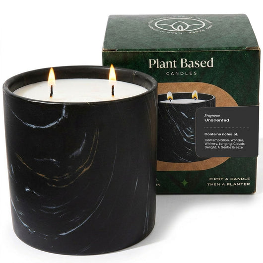 Unscented black marquina candle in marbled glass jar with flame, boxed label behind