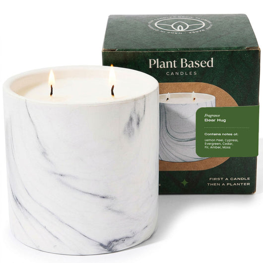 White marble-pattern candle with matching box behind, two wicks lit.
