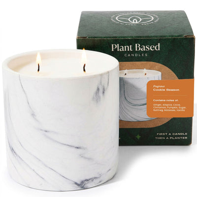 White marble patterned candle jar with two flames, plant-based candle box behind