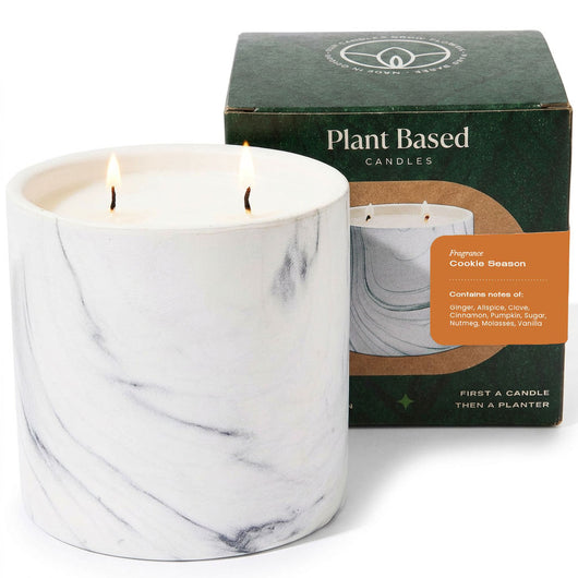 White marble patterned candle jar with two flames, plant-based candle box behind