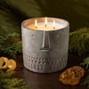 Stone face candle in gray speckled jar, three wicks burning