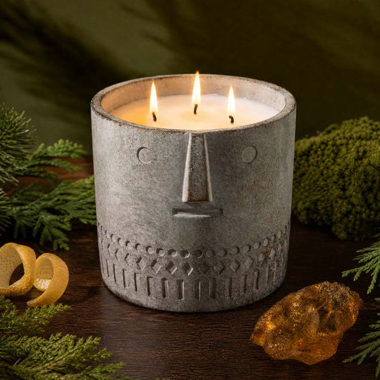 Stone face candle in gray speckled jar, three wicks burning