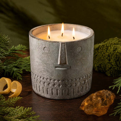 Stone face candle in gray speckled jar, three wicks burning
