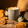 Textured gray stone-face candle with three wicks and steady flames