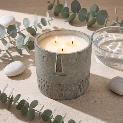 Eucalyptus stone face candle, gray textured jar with four flames on table