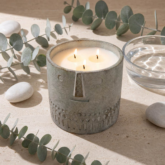 Eucalyptus stone face candle, gray textured jar with four flames on table