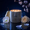 Stone Face candle in blue-gray stone-look jar, three visible flames, face motif front