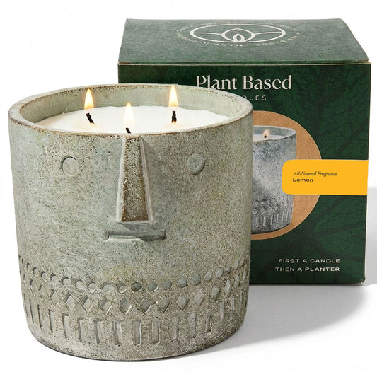 Gray textured face candle jar with three flames, in box packaging behind