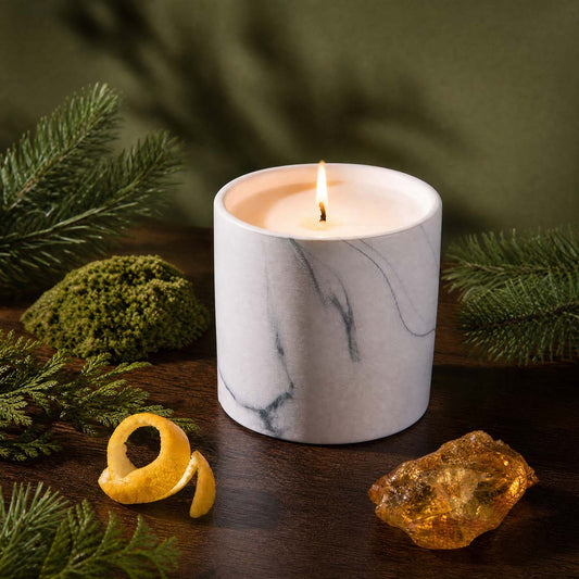 Marble-swirled white candle with lit wick
