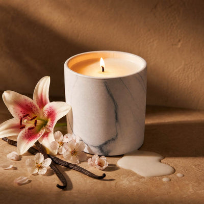 White marble candle jar with lit wick and smooth white wax