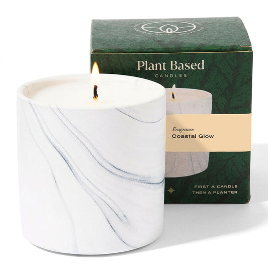 White marble-style glass jar candle with lit wick, in green Plant Based box