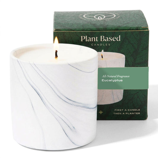 Marble-style white candle jar with lit wick and green eucalyptus label