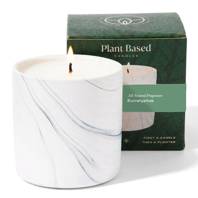 Marble-style white candle jar with lit wick and green eucalyptus label