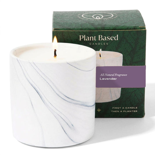 White marble-style soy candle in a glass jar, with wick flame and gift box
