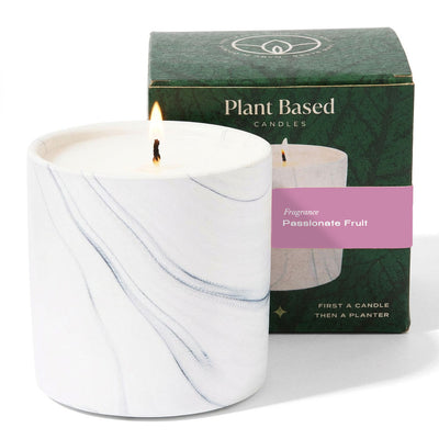 White marble scented candle jar, lit, with gift box behind