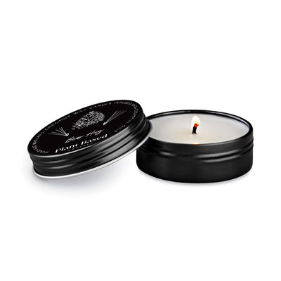Black tealight tin with lid open, lit wick flame visible