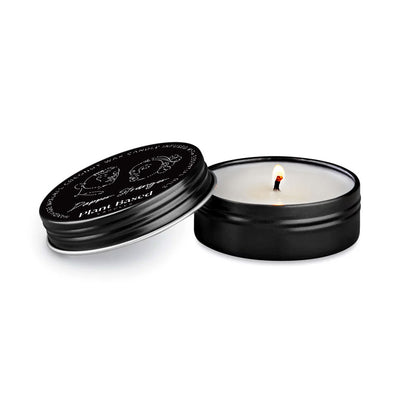 Tealight candle in black metal tin, open lid showing lit white wax