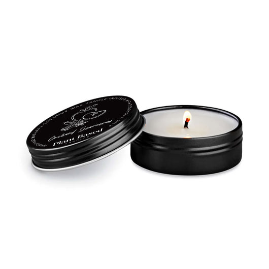 Tealight candle in dark tin with lid open, small flame visible