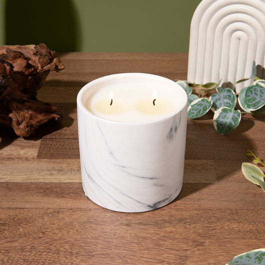 White marble-pattern candle jar with two lit wicks